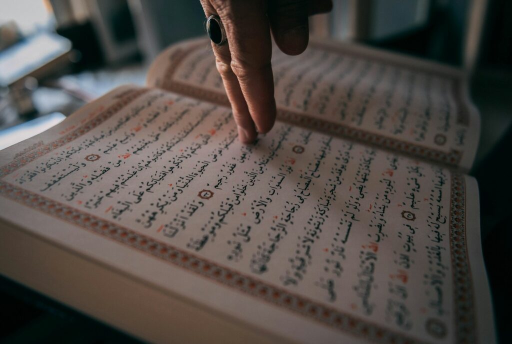 A person's hand on a book with writing on it