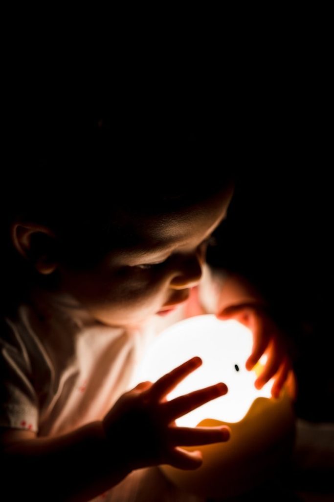 boy in gray shirt holding lighted ball